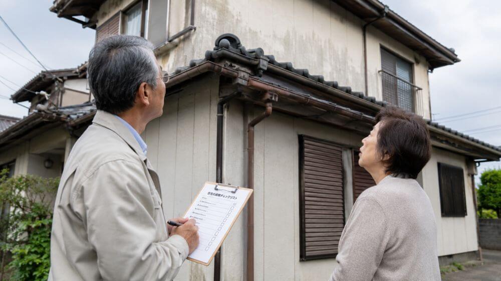 築年数の古い家の外壁や屋根を確認しながらチェックリストを見る
